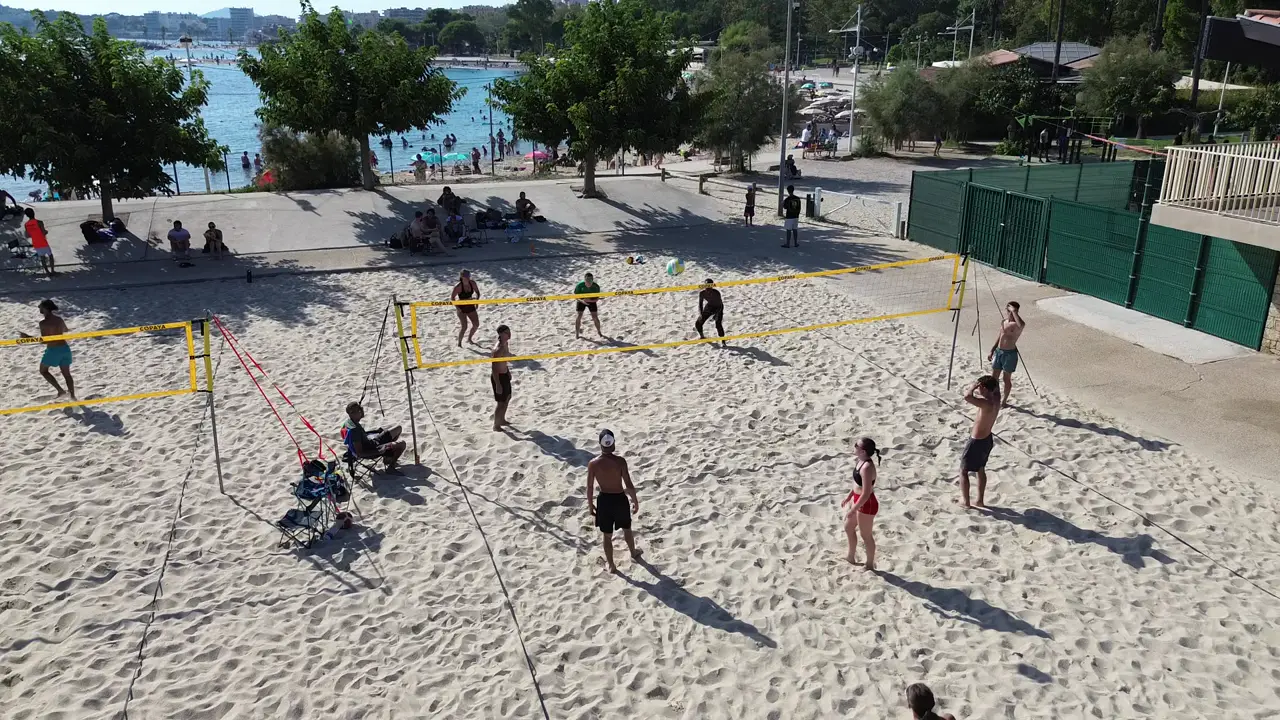 Vue aérienne des terrains de beach volley de la plage du Mourillon à Toulon, avec les joueurs de l'association et la mer en arrière-plan
